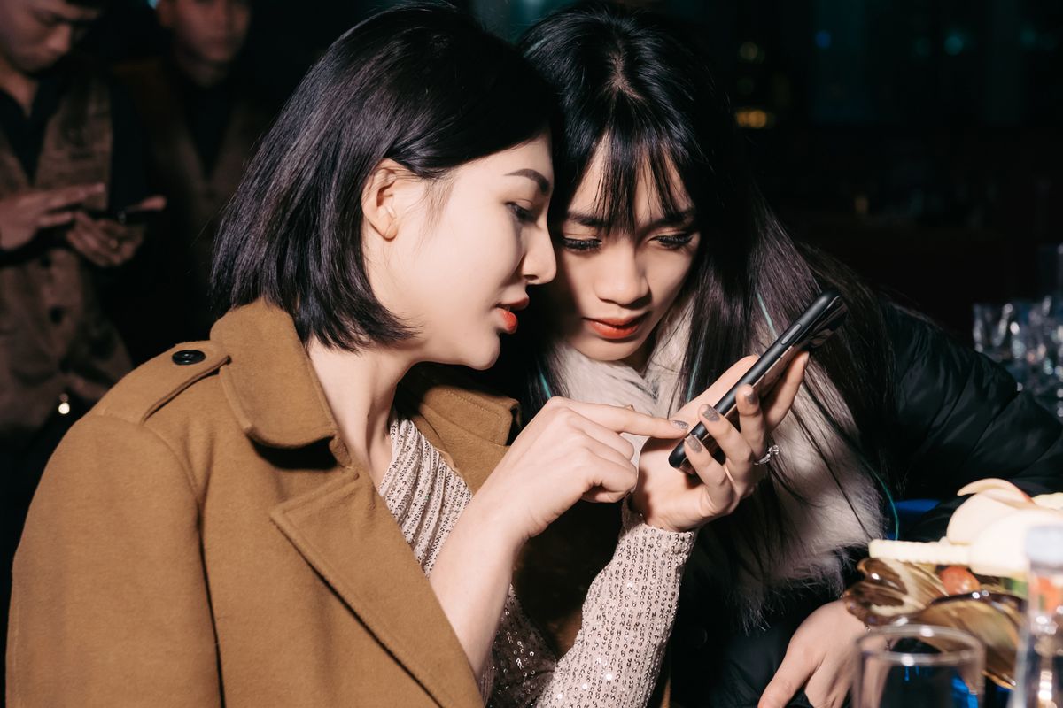 Dos personas mirando una entrada en el celular en una salida nocturna
